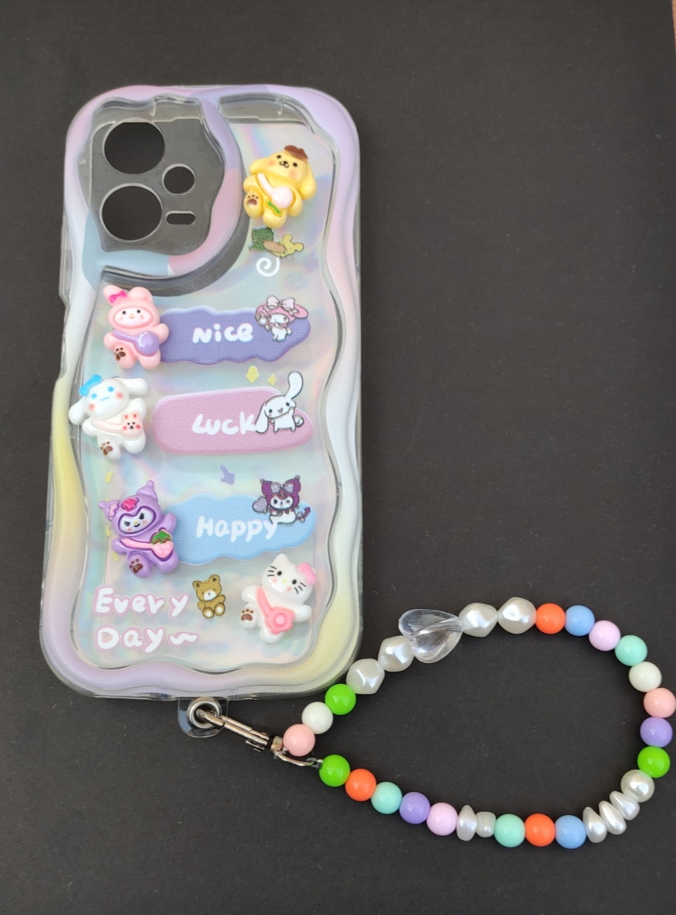 کاور هلوکیتی Note 12، قاب آویزدار Note12، کاور فانتزی شیائومی آویز دار Alt: کاور آویزدار Xiaomi Note 12 5G با عروسک‌های کرومی و هلوکیتی و مهره رنگی