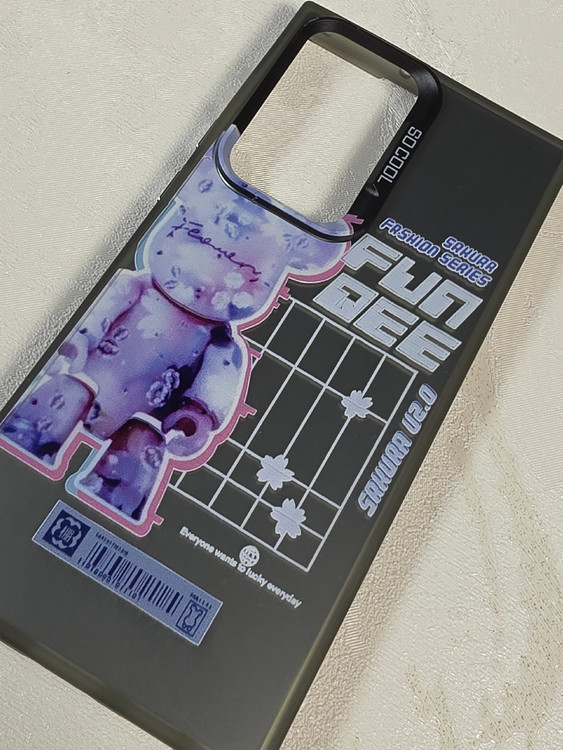 قاب نیمه شفاف دودی گوشی سامسونگ S23 Ultra با طرح گرافیکی خرس بنفش Bearbrick و نوشته Sakura Fashion