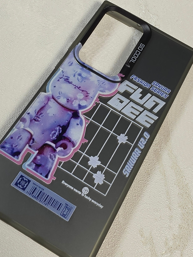 قاب نیمه شفاف دودی گوشی سامسونگ S23 Ultra با طرح گرافیکی خرس بنفش Bearbrick و نوشته Sakura Fashion